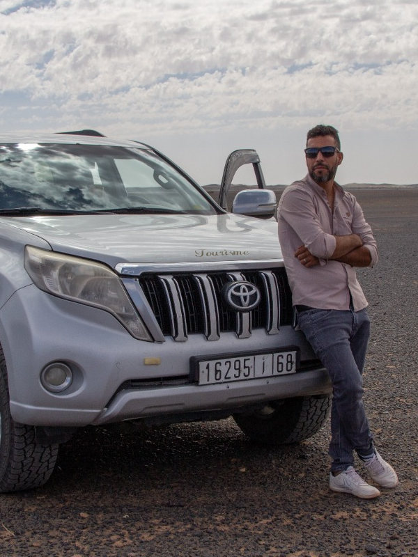 Guía de Top Marruecos apoyado en su coche 4x4
